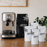 Espresso machine with Little Italy coffee bags on a wooden surface