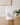 White packaging with 'Press Pump & Grind' text on a wooden surface with a plant in the background